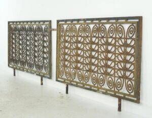Pair of decorative metal grills with spiral scrollwork, shown as a pair and angled side by side.