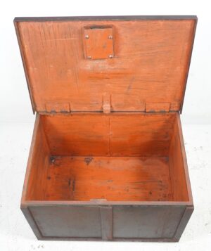 Open brown metal vault unit with a hinged lid, showing the empty interior and worn surface on the steel and cast iron box.