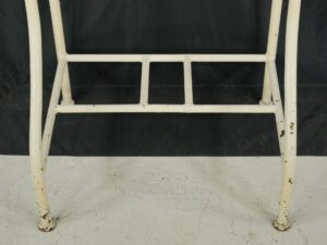 White steel hall tree stand shown from the lower section, with a bottom shelf support and visible surface wear with minor rust spots.