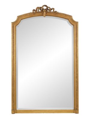 Arched wall mirror with a ribbon crest, fluted frame, and aged mirror surface.