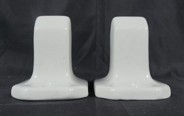 Pair of white ceramic towel bar brackets with a crackle porcelain finish, shown side by side.