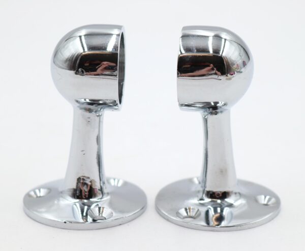 Pair of chrome towel bar brackets shown as a matching set, each with a rounded top, narrow stem, and circular base with mounting holes.