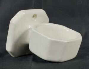 White ceramic wall cup holder with a crackle finish and a recessed mounting hole, shown in a close-up view of the cup-shaped holder and back plate.