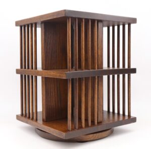 Mid century modern desktop bookcase in dark wood tone with open vertical slats, shown on its swivel base.