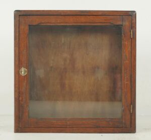 Vintage industrial display cabinet with a dark wood tone frame, glass front, and brass latch.