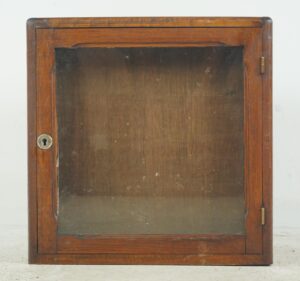Vintage shop display cabinet with a dark wood frame, glass front, and brass lock and hinges.