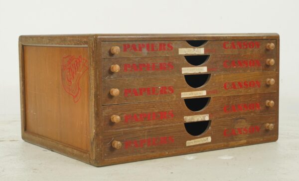 Vintage oak paper storage cabinet with five drawers, red PAPIERS CANSON stenciling, and visible surface wear.