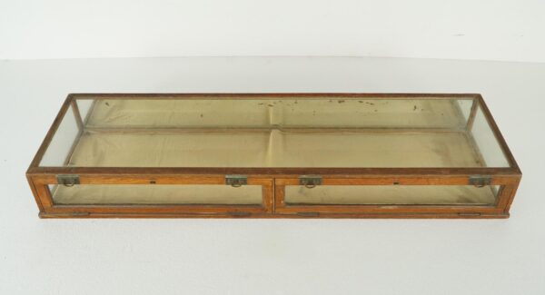 Vintage collector’s display case with a dark wood frame, clear glass panels, and a mirrored back, shown with the front access panels closed and brass hardware visible.