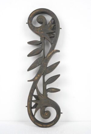 Art Nouveau bronze metal piece with spiral ends, leaf-like details, and side lugs, shown vertically with worn antique bronze finish.