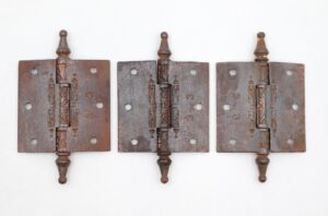 Set of three Victorian cast iron butt door hinges with steeple tips and decorative cutout detail, shown front view with the screw hole pattern visible.