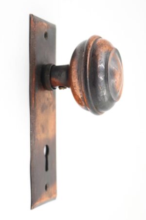 Vintage dummy door knob set with a concentric brass knob on a flat back plate, shown in side view.