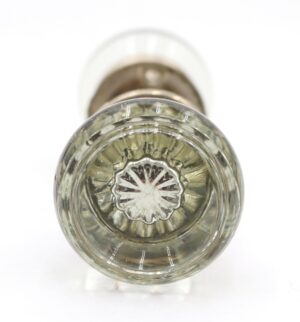 Close-up of a clear glass door knob with a brushed nickel rosette, shown from the end.