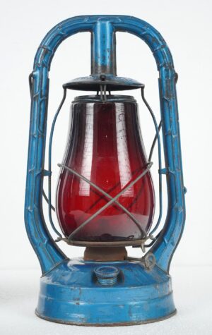 Vintage kerosene lantern with a blue steel frame and red glass globe shown from the front.