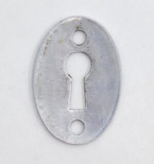 Oval chrome keyhole cover plate with two screw holes and a large center keyhole opening, shown front view with visible surface wear.