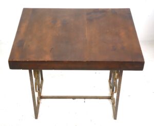 Side table with a dark wood tone reclaimed pine top and wrought iron base, shown from above with visible heart and scroll motifs on the legs and wear on one corner of the tabletop.