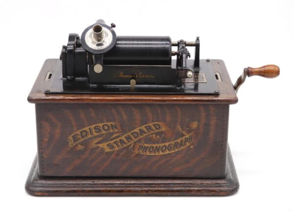 Antique Edison Standard phonograph with a hand crank, black mechanism, and dark wood base.