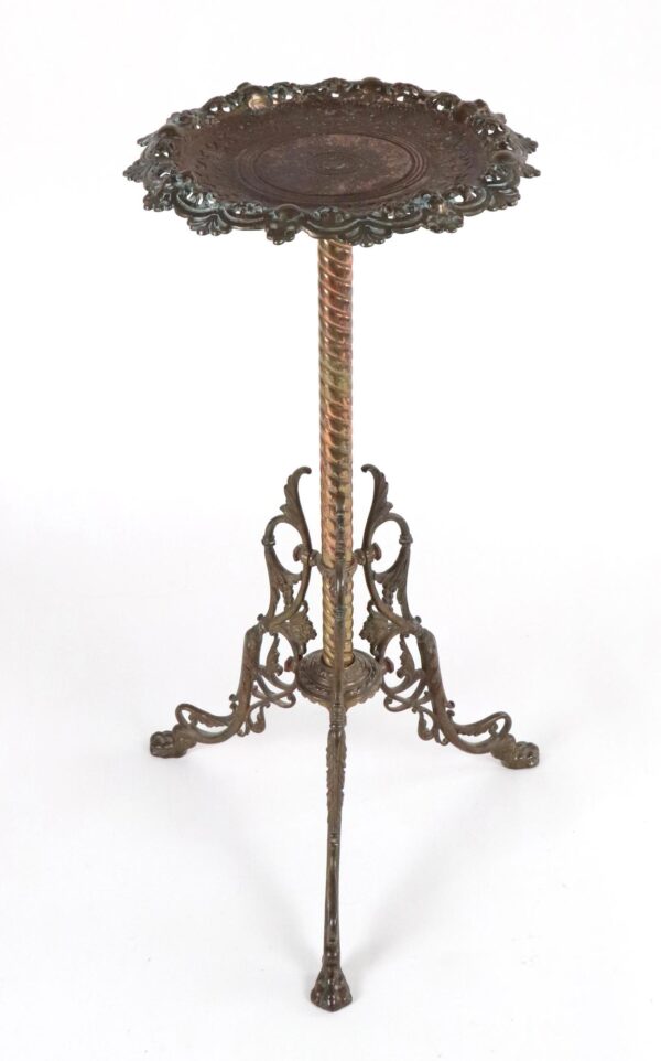 Victorian brass plant stand with a scalloped embossed top, twisted central column, and scrolling legs.
