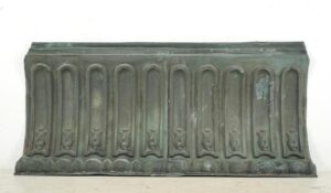 Antique copper cornice wall art with verdigris patina, showing a long rectangular panel with repeated arched recesses and a visible mounting wire attached at the back.