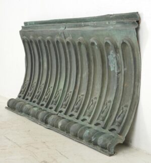 Antique copper cornice wall art with a verdigris finish, shown at an angle with ribbed detailing and a mounting wire attached to the back.