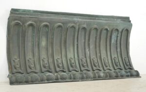Antique architectural copper cornice wall art with a verdigris finish, shown as a long decorative panel with repeating arched details and a rounded lower border.