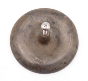 Round vintage brass drawer pull shown from the back with a central mounting screw and visible surface wear.