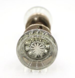 Clear glass passage door knob shown from the end, with a brushed nickel rosette visible behind it.