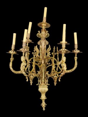 French Louis XV gilt bronze wall sconce with seven candle-style lights, ornate scrolling arms, putti figures, an urn finial, and a female bust at the center.