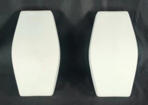 Pair of mid century modern milk glass wall sconces shown side by side, each with a tall coffin-shaped white glass shade and a black rectangular mount visible behind it.