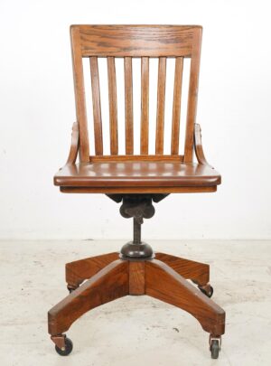 Antique swivel desk chair with a vertical slatted back, contoured seat, and star base on casters.