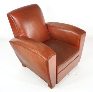 Art Deco leather club chair with a flat square back, cigar-style armrests, and worn wood block feet.