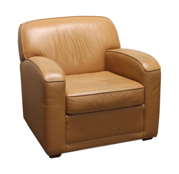 Tan leather club chair with a low profile, curved arms, and a deep seat shown from the front at a slight angle.