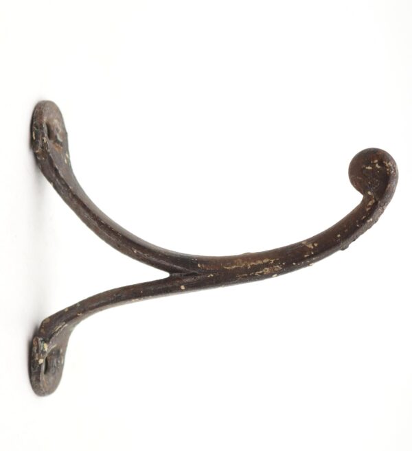 Vintage cast iron wall hook with a curved single arm, ball tip, and two mounting points visible at the ends.
