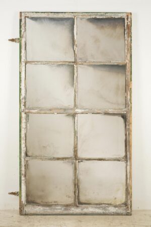 Handcrafted mirror made from a reclaimed window frame with eight panes and original hinges attached.