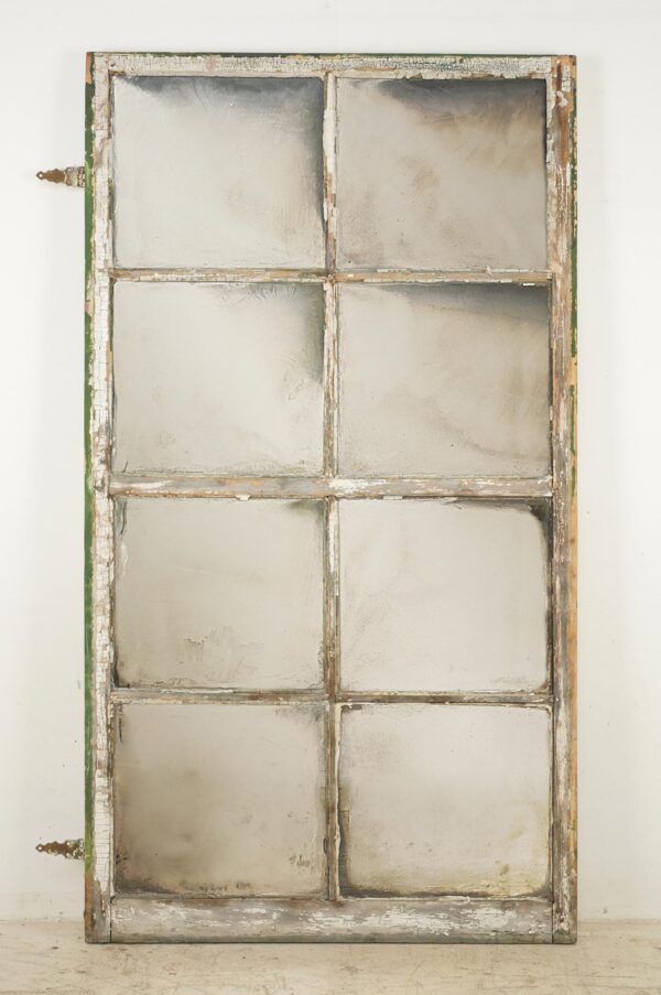 Handcrafted mirror made from a reclaimed window frame with eight panes and original hinges attached.