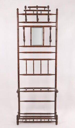 Victorian hall tree in a dark wood tone with turned bamboo-style detailing and a beveled mirror at the center.