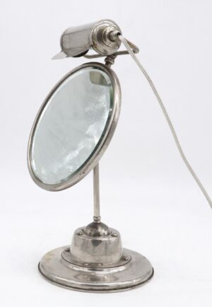 Vintage nickel-plated shaving mirror with a round base, beveled glass, and a built-in light at the top.