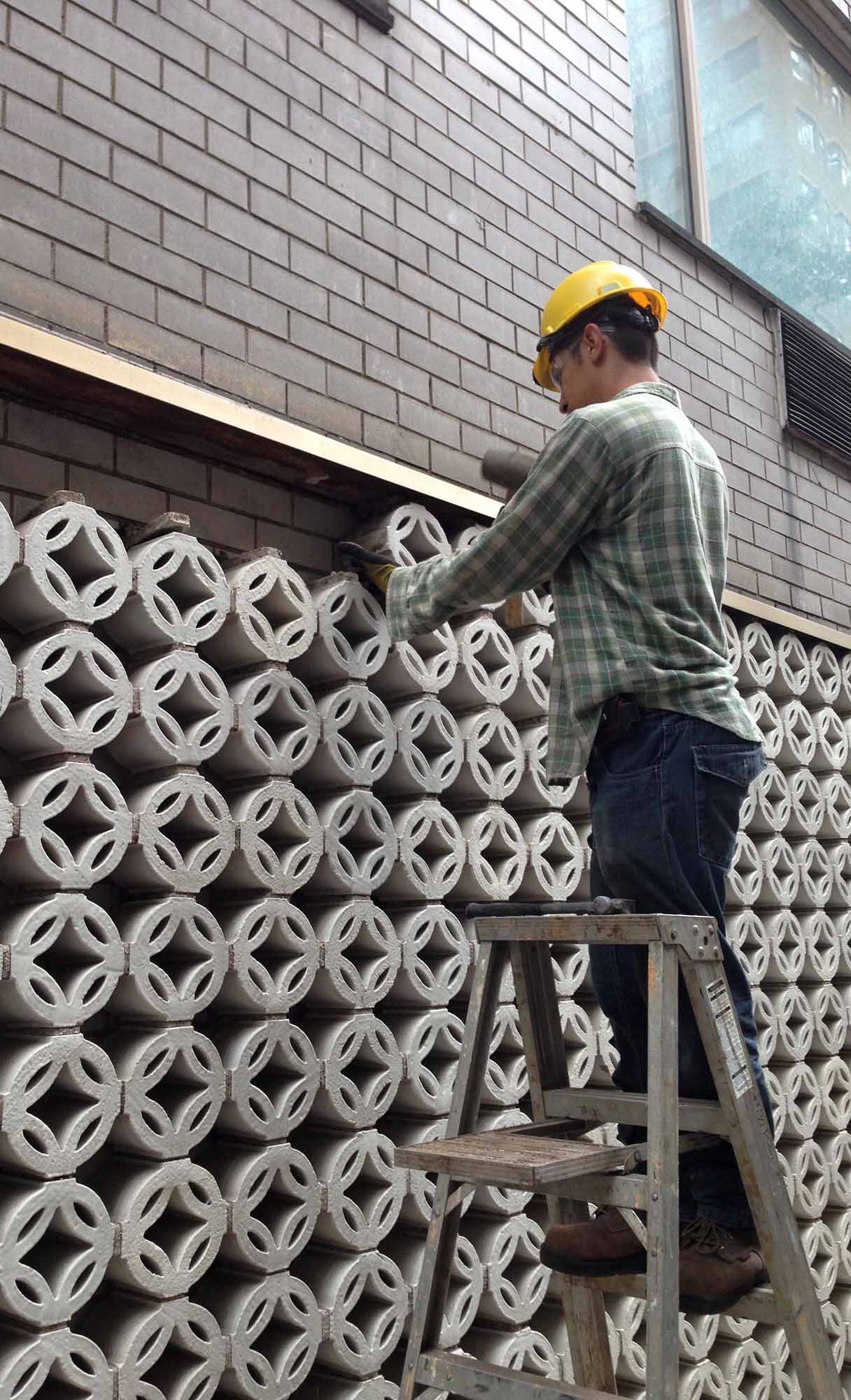 Removal of white terra cotta privacy bricks.