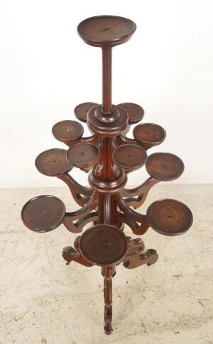 Victorian freestanding plant stand in dark wood tone with multiple round tiers and fretwork detailing, shown from above.