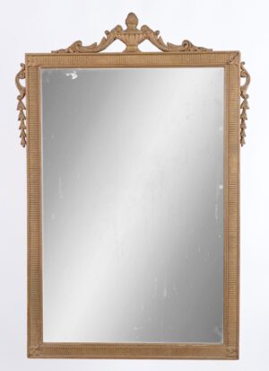 Louis XVI style wood wall mirror with an ornate carved frame, foliate urn crest, and a gold painted finish, shown with visible age spots on the mirror surface.