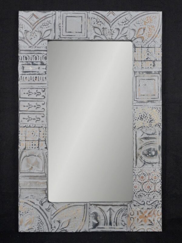 Rectangular wall mirror with a patchwork tin frame around a plain reflective center.
