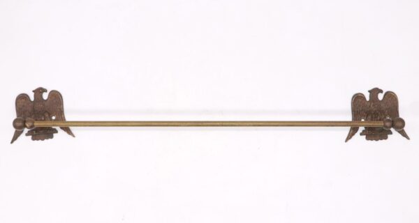 Antique brass towel bar with eagle motif wall brackets and a long rod.