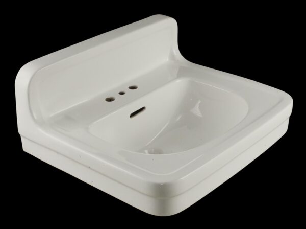 White ceramic wall sink with backsplash and a half-moon basin, shown in a three-quarter view with three faucet holes and a side drain opening.
