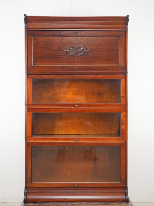 Victorian-style barrister bookcase with a writing bureau and three glass-front storage compartments, shown front view with round brass pulls and a decorative carved panel on the upper section.