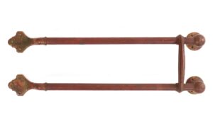 Pair of antique brass door push bars with a crossbar, shown front view with rounded tops and decorative lower plates.