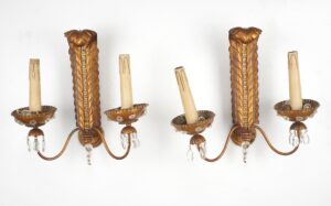 Pair of Rococo Revival wall sconces shown side by side, each with two candle-style arms, a gilded scrollback, and hanging crystal prisms beneath the bobeches.