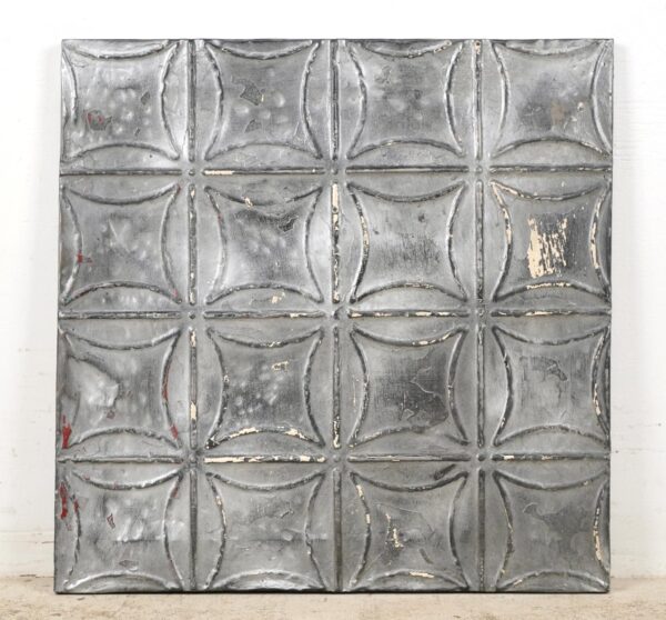 Handcrafted gray tin wall panel with a geometric raised pattern and worn antique finish.